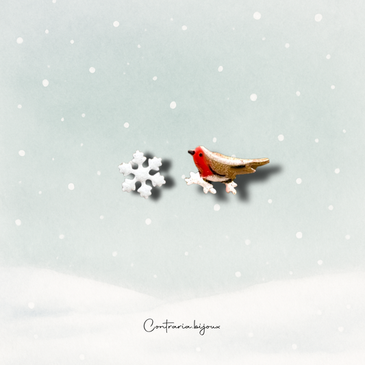 Orecchini pettirosso sulla neve  e fiocco di neve