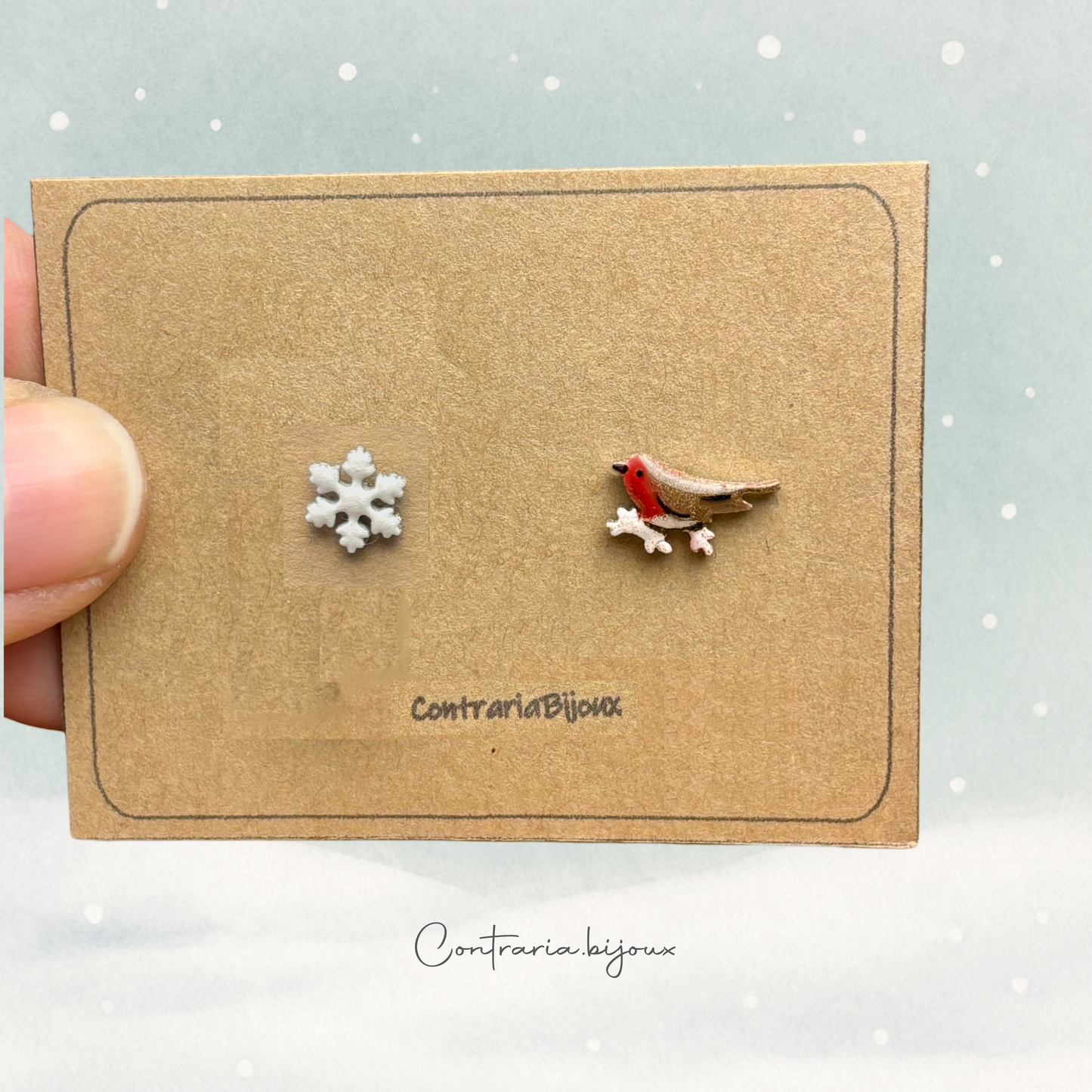 Orecchini pettirosso sulla neve  e fiocco di neve